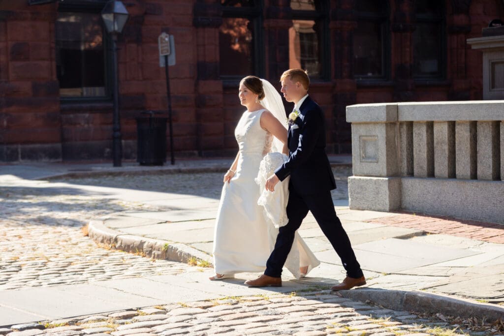 Erin and Alex crossing the cobblestone street in New Bedford, Massachusetts